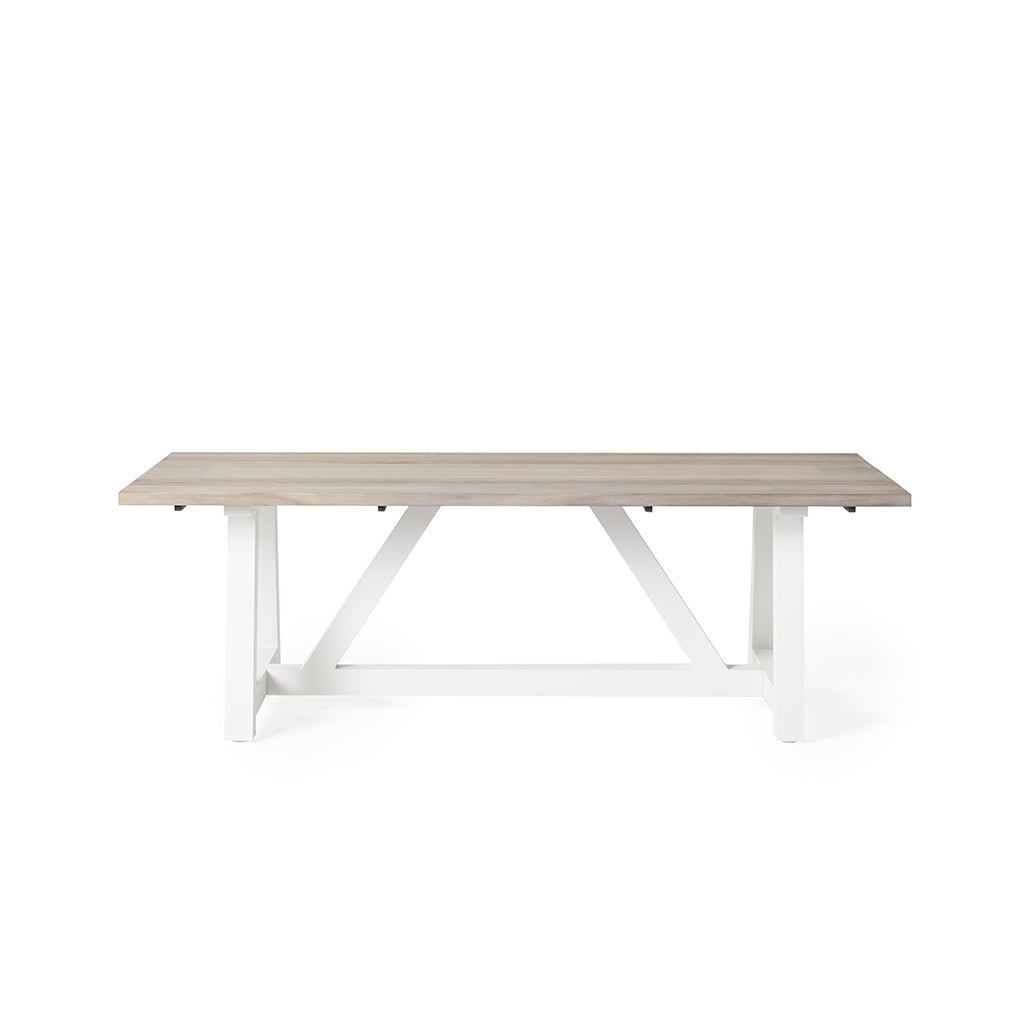 Madera Dining Table with Weathered Teak Top by Terra Outdoor Living has a white aluminum trestle base, topped with planks premium teak in a weathered finish. Also available with a charcoal colored base.