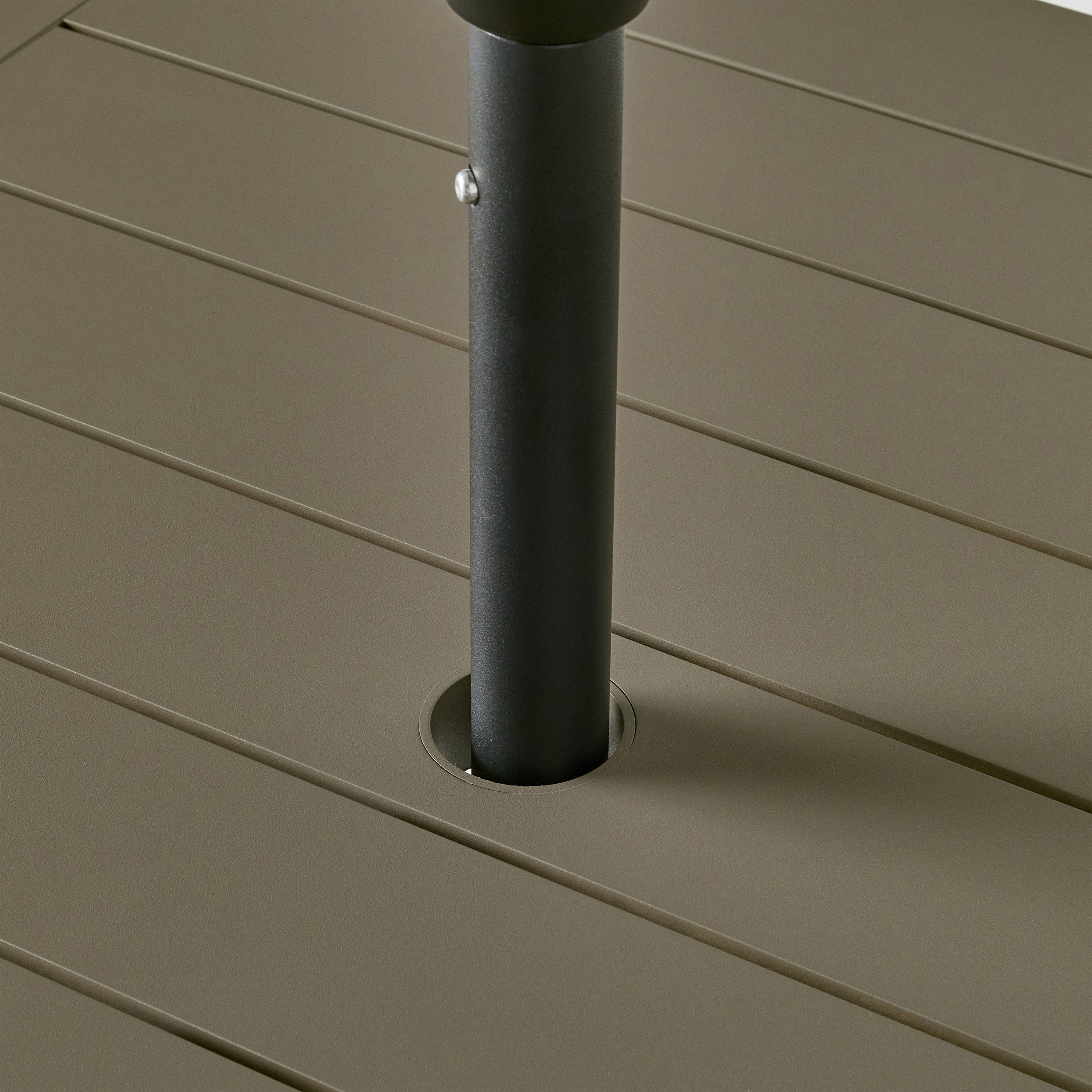 Belvedere Square Dining Table by Terra Outdoor Living in Quartz Grey, a warm grey tone, shown with a slatted aluminum top and central umbrella hole, featuring a clean-lined, modern silhouette in a compact size for versatile outdoor placement. Close up showing umbrella fitted through hole to demonstrate functionality.