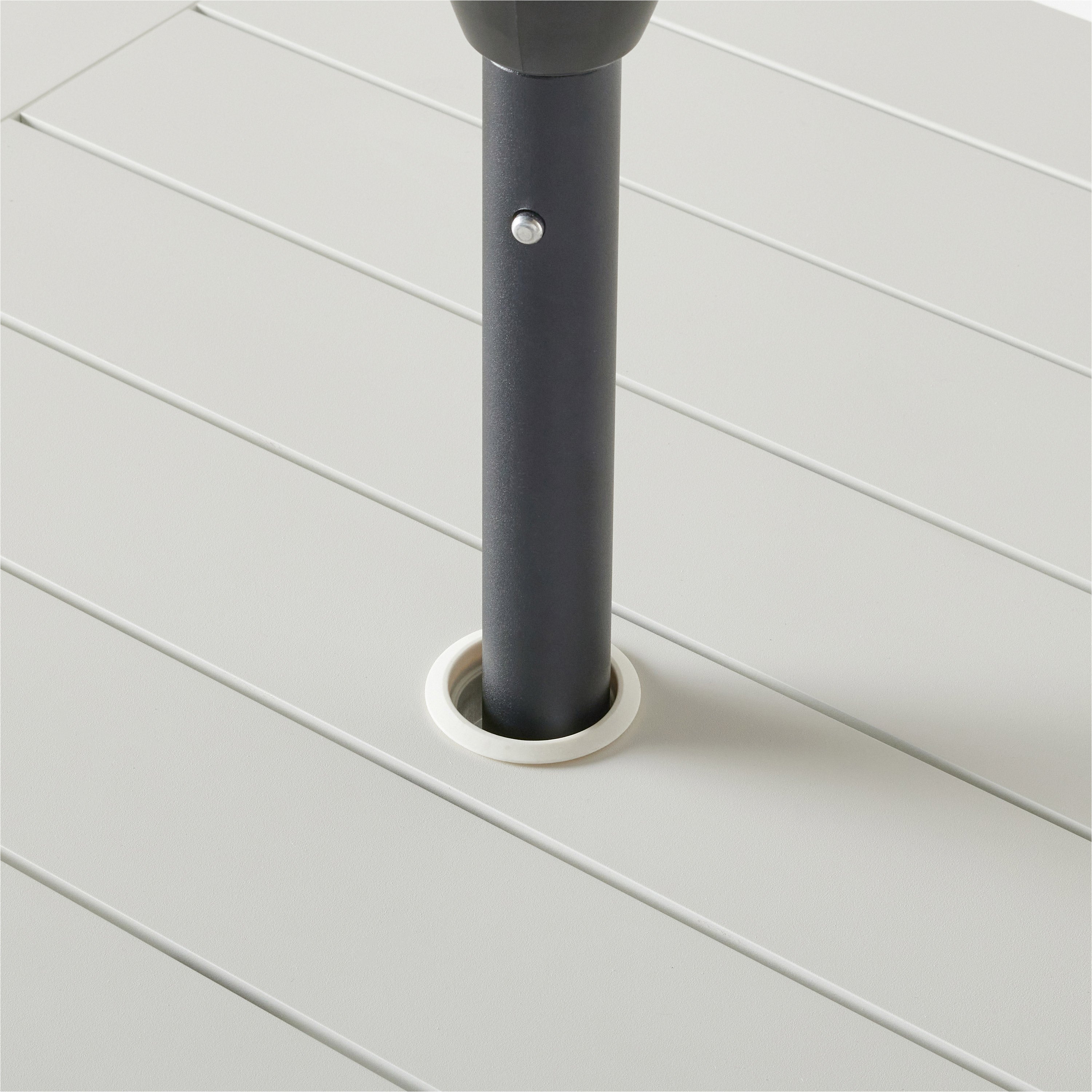 Belvedere Square Dining Table by Terra Outdoor Living in White, shown with a slatted aluminum top and central umbrella hole, featuring a clean-lined, modern silhouette in a compact size for versatile outdoor placement. Close up shown with an umbrella fitted through the hole to demonstrate functionality.