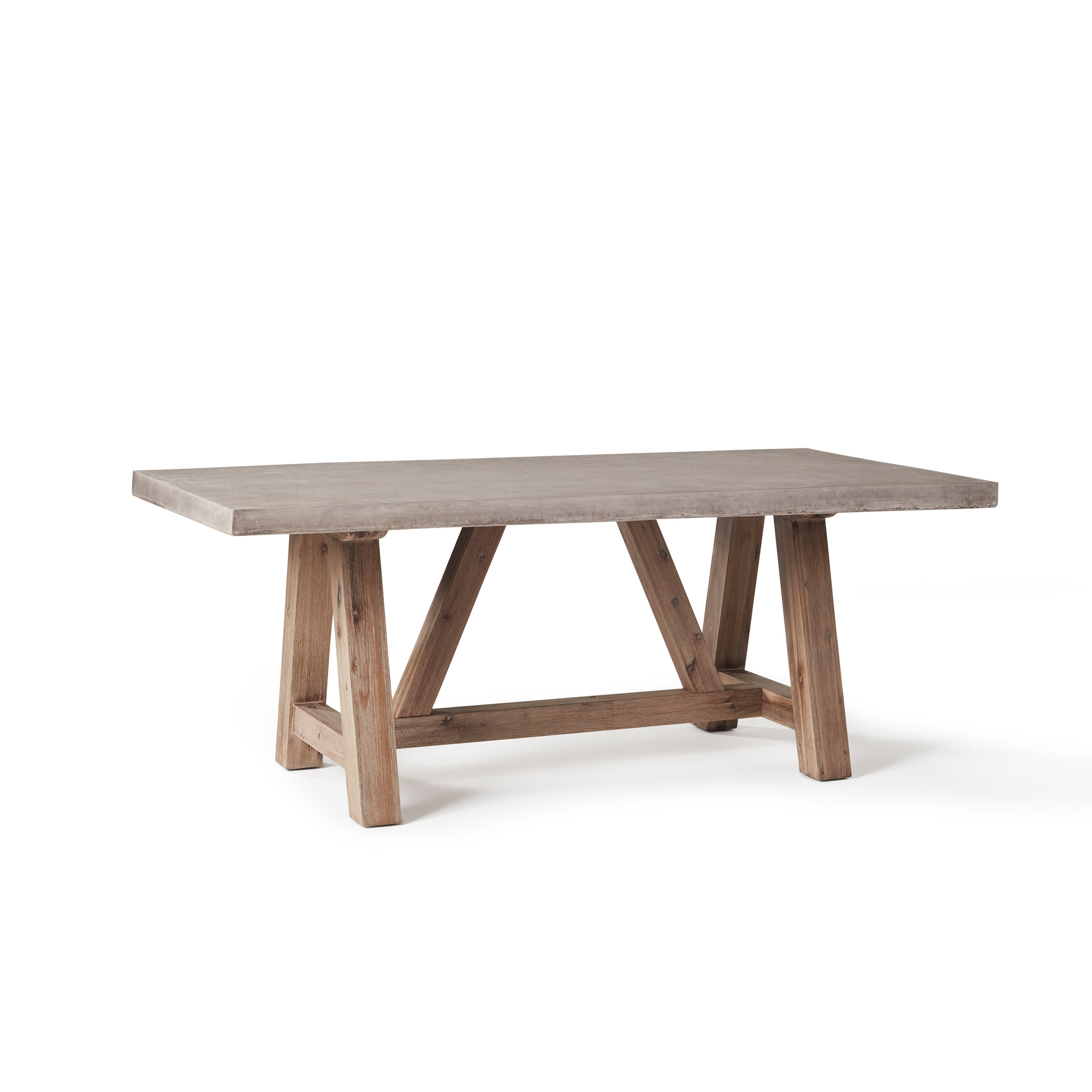 The Bordeaux 79" Dining Table by Terra Outdoor Living pairs a rustic acacia wood base inspired by antique trestle tables with a top crafted from a composite that delivers superior weather-resistance and durability with all the industrial appeal of concrete.