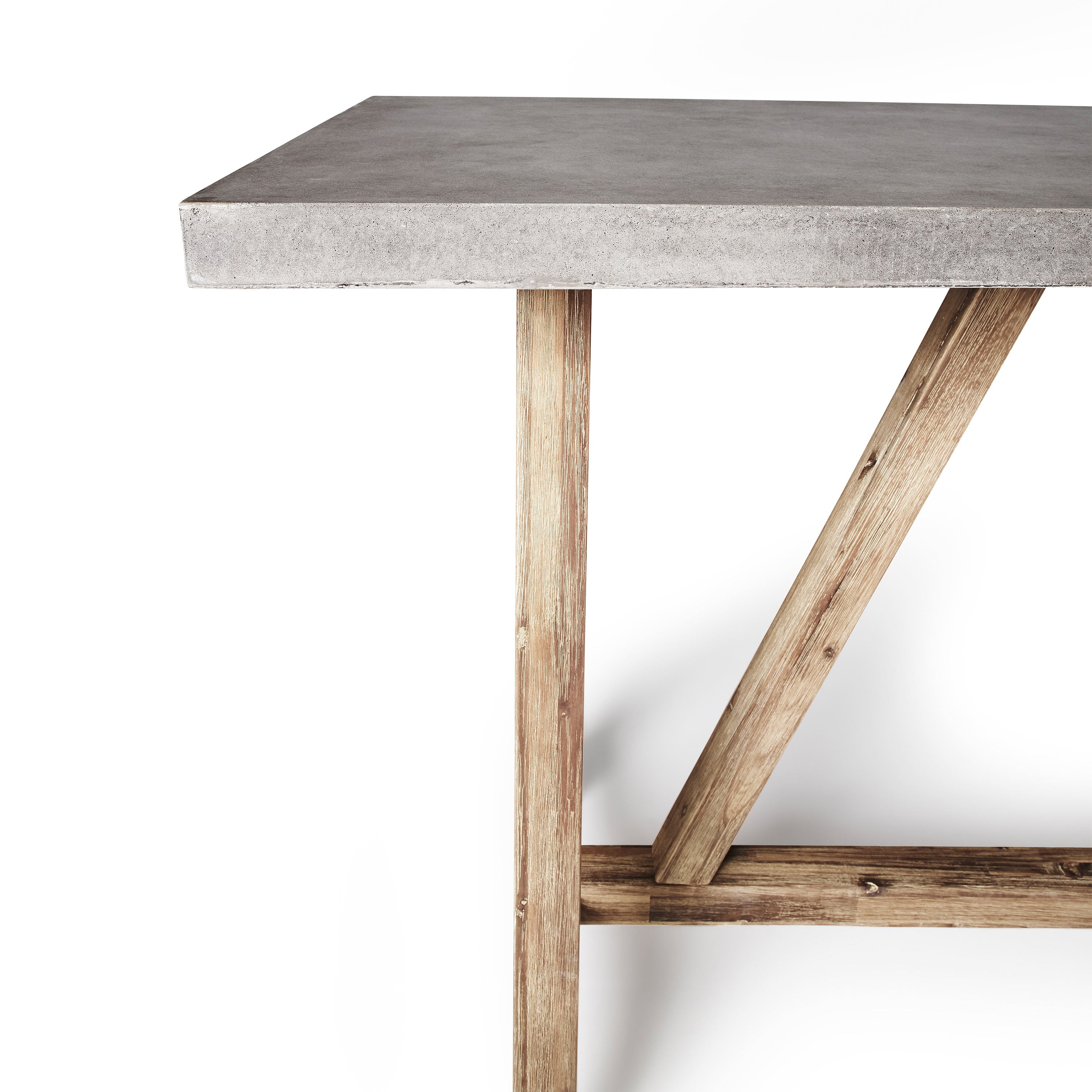 close up of The Bordeaux Bar Table by Terra Outdoor Living pairs rustic acacia wood bases inspired by antique trestle tables with tops crafted from a composite that delivers superior weather-resistance and durability with all the industrial appeal of concrete (GFRC)
