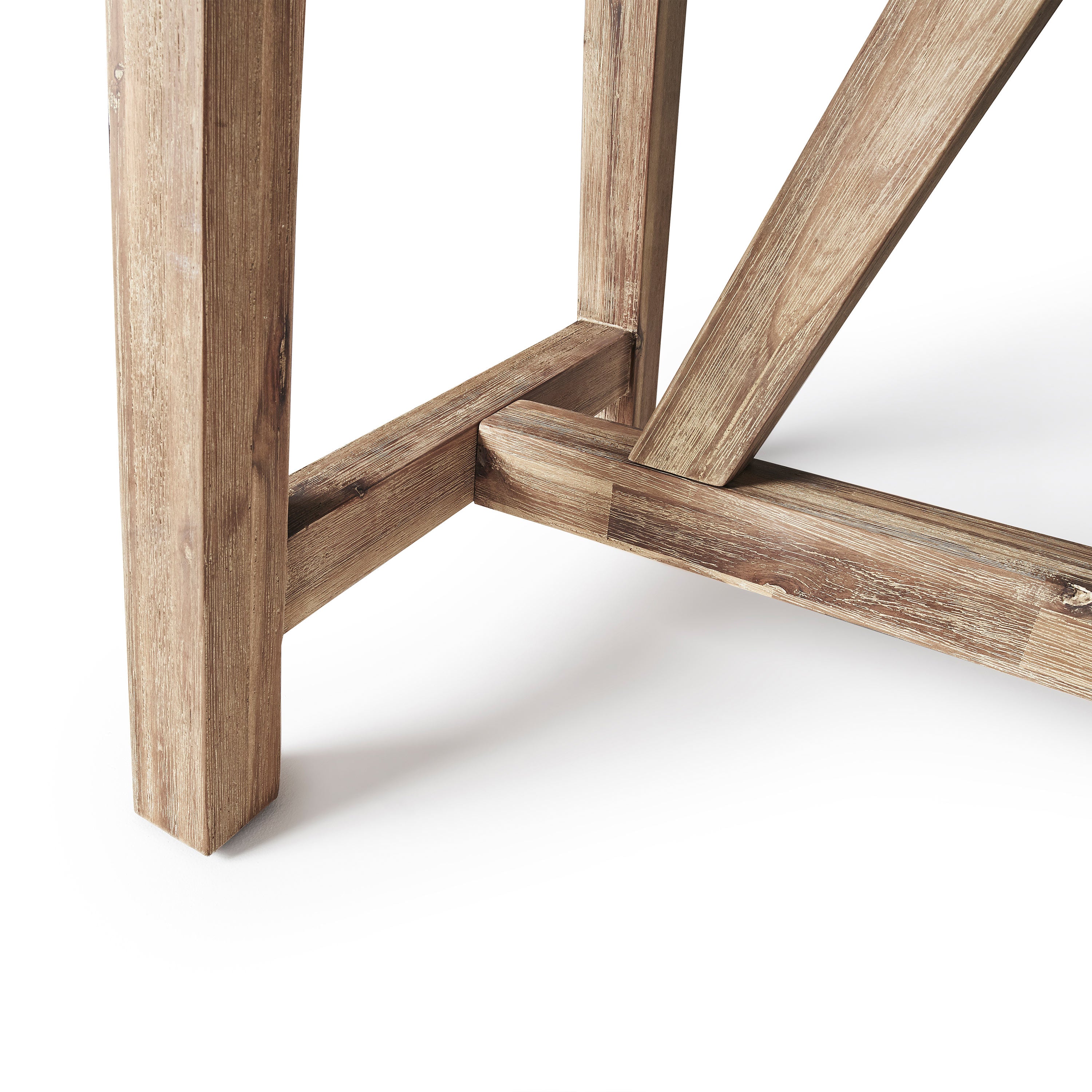 The Bordeaux Bar Table by Terra Outdoor Living pairs rustic acacia wood bases inspired by antique trestle tables with tops crafted from a composite that delivers superior weather-resistance and durability with all the industrial appeal of concrete (GFRC). Image shows close up of the trestle style base.