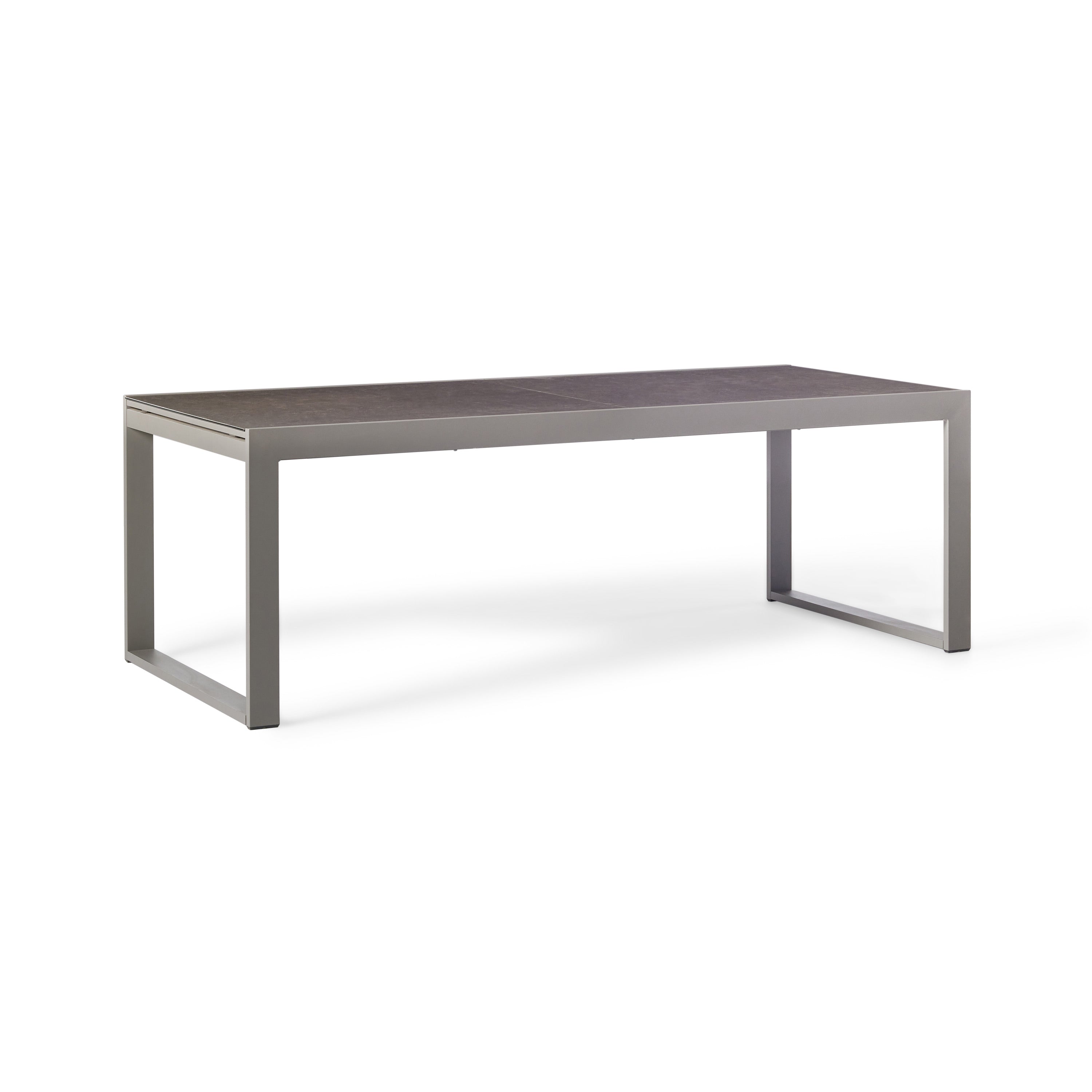 Diablo 87"-130" Extension Dining Table in Quartz Grey by Terra Outdoor Living is an extension dining table, with sled-style powdercoated aluminum frame and 'ceramic' coated tempered safety glass as the table top. It has a sleek modern look and can extend to suit the moment. Image shows table un-extended.