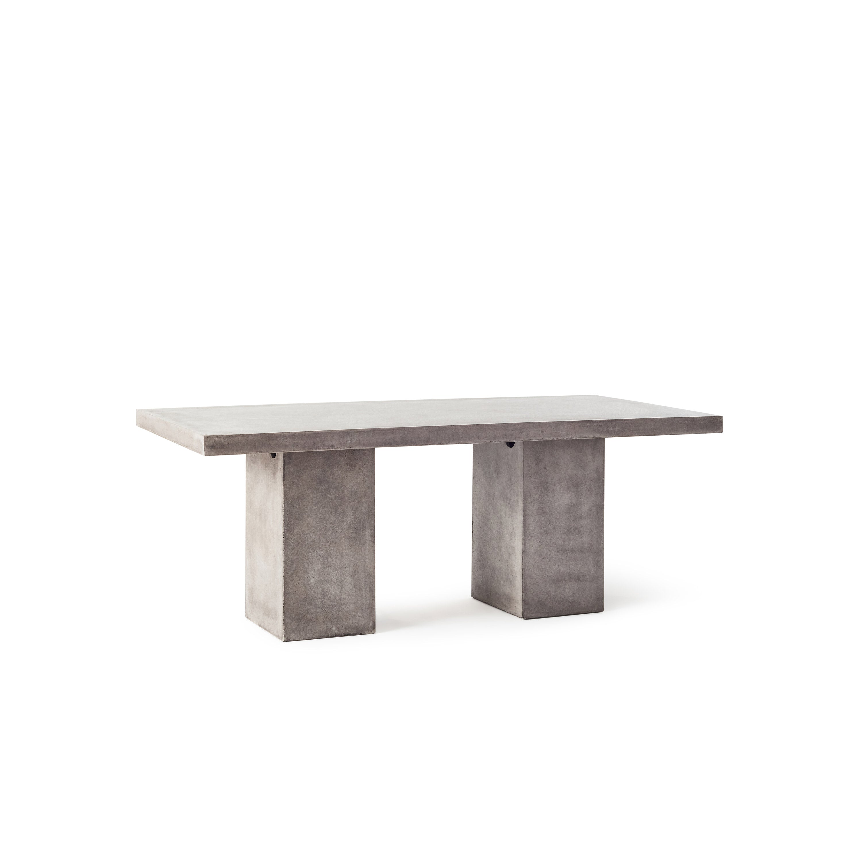Mason 79" Dining Table by Terra Outdoor Living is made entirely of Glass Fiber Reinforced Concrete (GFRC), which resembles the look and feel of concrete but at a fraction of the weight and with increased strength. It features two cuboid bases as legs, with a slab of thick-edged GFRC as the top.
