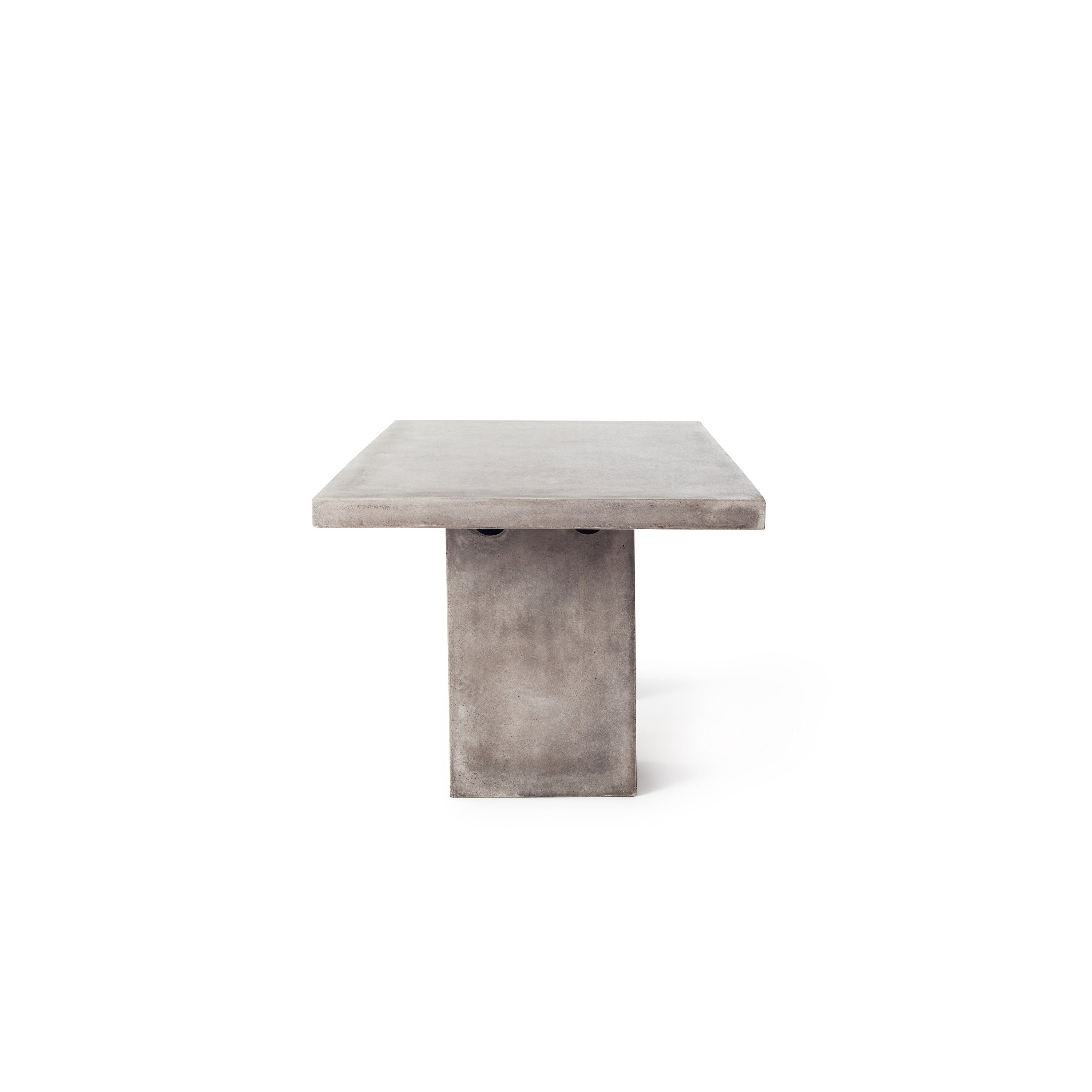 Mason 79" Dining Table by Terra Outdoor Living is made entirely of Glass Fiber Reinforced Concrete (GFRC), which resembles the look and feel of concrete but at a fraction of the weight and with increased strength. It features two cuboid bases as legs, with a slab of thick-edged GFRC as the top.