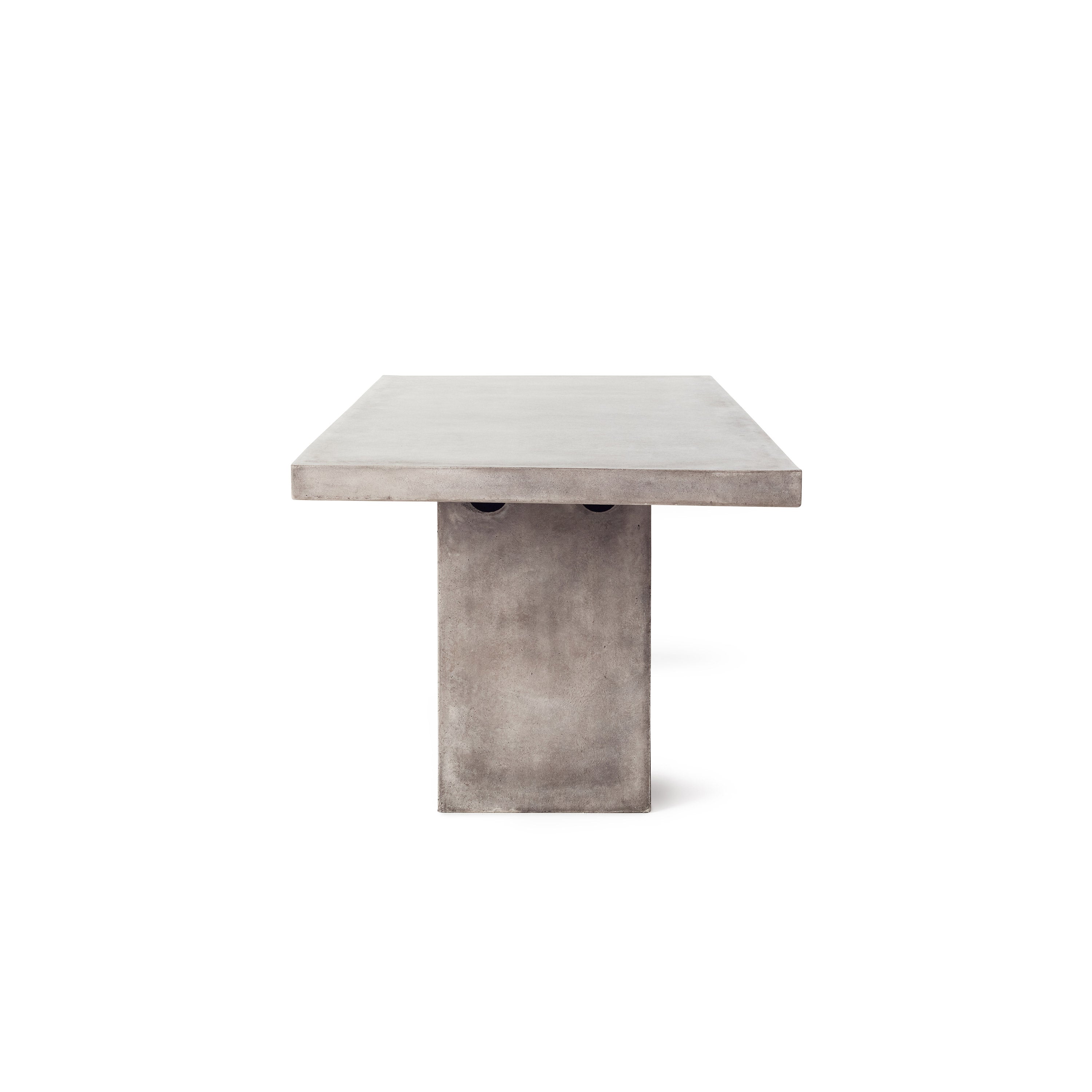 Mason 95" Dining Table by Terra Outdoor Living is made entirely of Glass Fiber Reinforced Concrete (GFRC), which resembles the look and feel of concrete but at a fraction of the weight and with increased strength. It features two cuboid bases as legs, with a slab of thick-edged GFRC as the top.