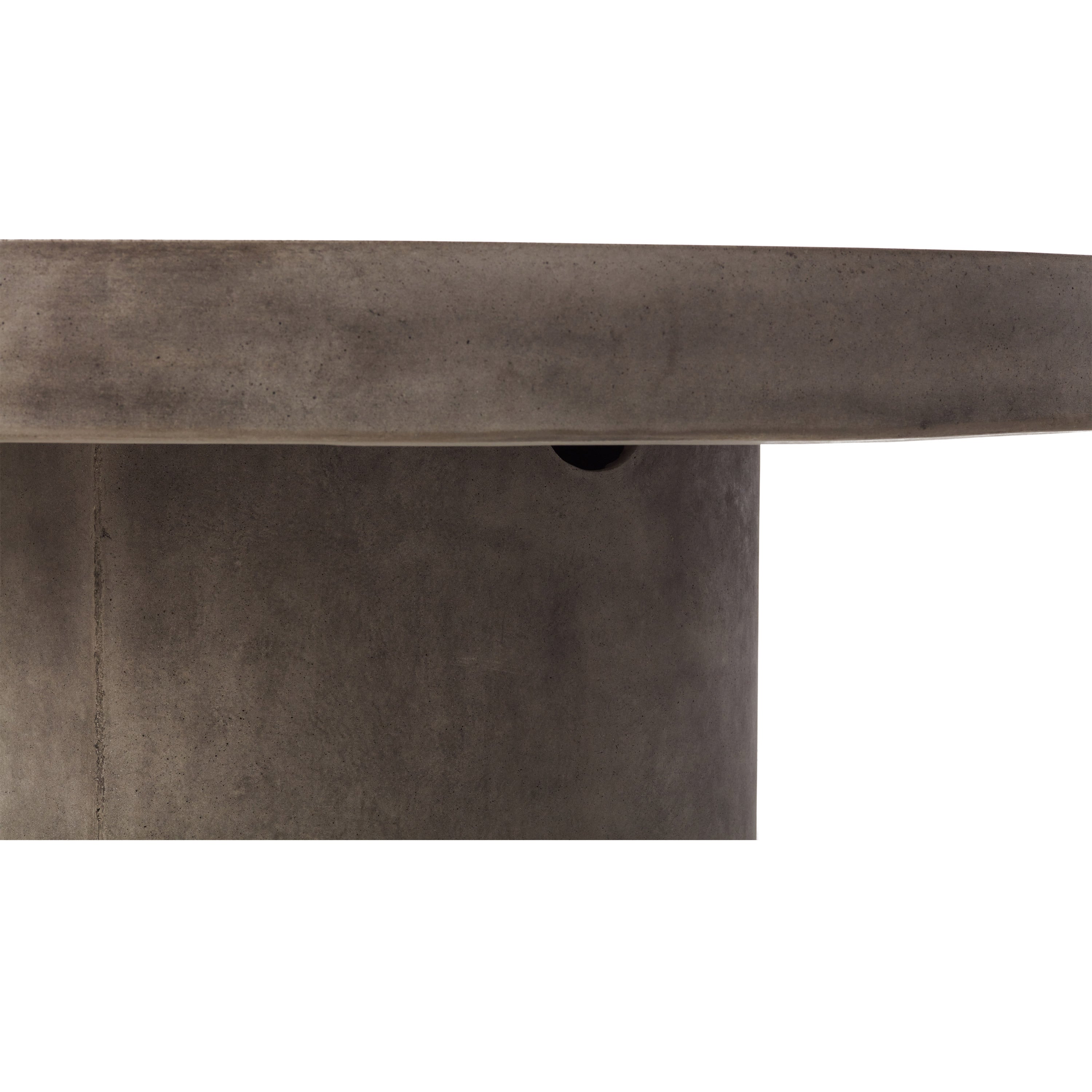 Mason Floating Round Coffee Table by Terra Outdoor Living is made entirely from Glass Fiber Reinforced Concrete (GFRC) - its surface effect resembles that of industrial concrete. It features a cylindrical pedestal base, and a thick-edged round slab of GFRC as the top.