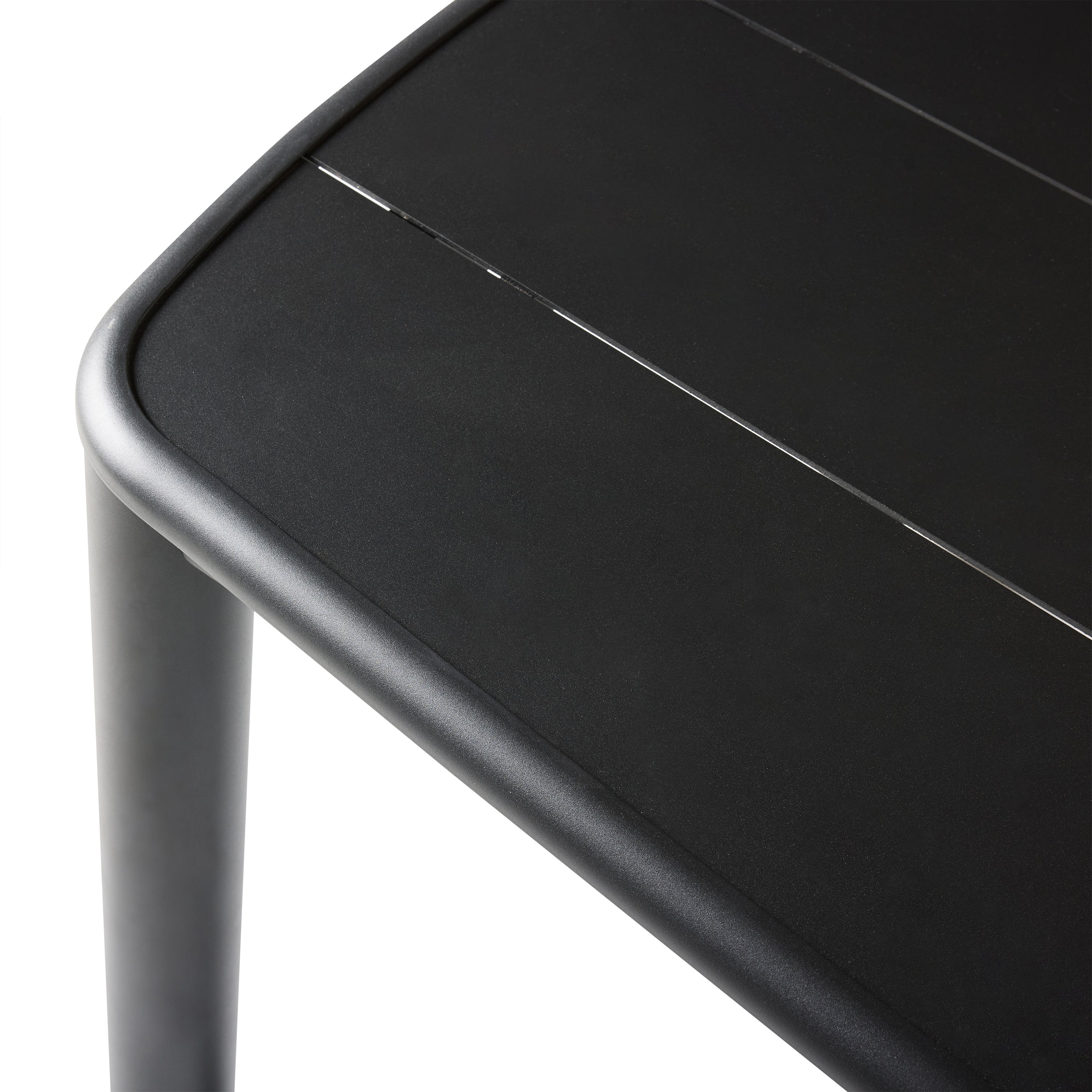 A close up of Stinson Dining Table in Aluminum by Terra Outdoor Living — crafted with a powdercoated aluminum frame in a charcoal finish, featuring a spacious slatted top that allows water to drain; comfortably seats up to 8 people, ideal for pairing with Stinson Dining Chairs or any of our dining chairs.