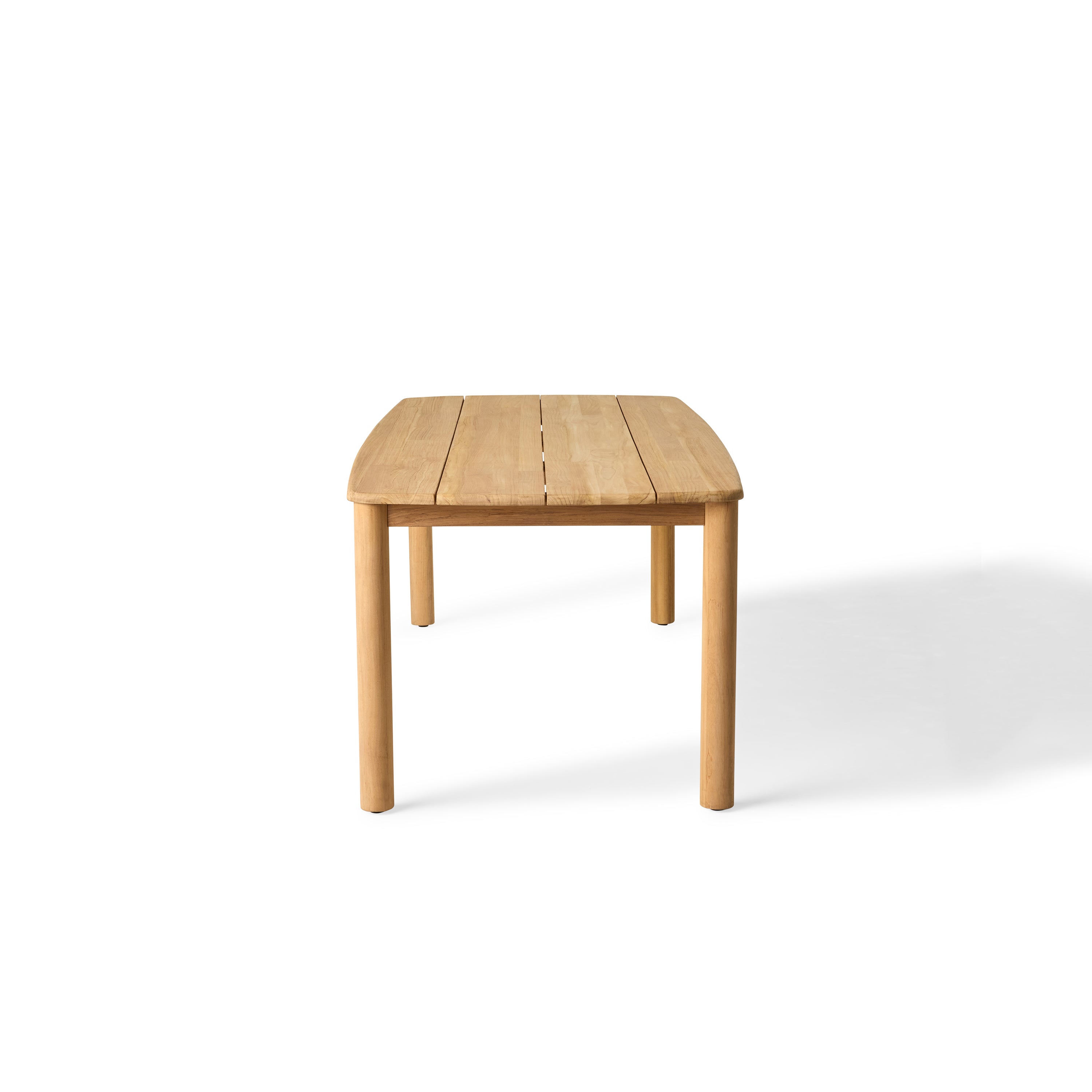 Stinson Dining Table crafted from premium teak in a natural finish, featuring curved edges and a spacious slatted tabletop seats up to 8 comfortably and allows water to drain, ideal for outdoor dining.